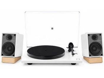 Giradischi in vinile Pro-Ject bianco con coperchio trasparente, piatto nero e due diffusori bianchi su supporti in legno