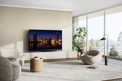 Televizor Panasonic TX-48MZ1500E zobrazující osvětlené město v noci, umístěný na nízkém nábytku ze světlého dřeva v moderním obývacím pokoji