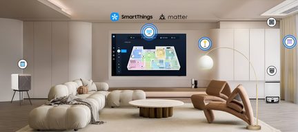 Sort vægmonteret fladskærm med slank grå metalramme, set forfra, viser et farverigt smart home-interface i en minimalistisk stue med beige møbler og tilsluttet tilbehør