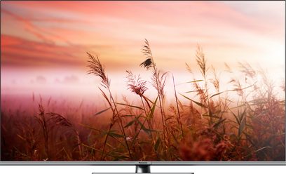 Televizor Panasonic TV-50W83AEG s vysokým rozlišením, pohled zepředu, na obrazovce je zobrazená krajina s poli, trávou a barevnou oblohou