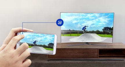 Dos pantallas de televisión que muestran la imagen de un hombre montando en bicicleta sobre una rampa de tierra, con las manos sujetando un smartphone