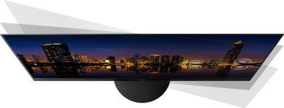 Televizor Panasonic TX-48MZ1500E zobrazující noční panoramatický pohled na osvětlené město odrážející se v hladině vody