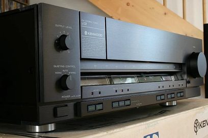 Vintage Kenwood L-02T stereoanvender, aluminiumsfacade, sorte knapper, grøn display, placeret på træhylde