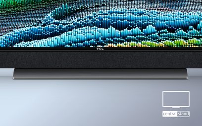 TCL 65X925 fladskærms-TV slukket, sort skærm, på sølvfarvet centralt stativ, viser et abstrakt billede af blå-grønne bølger