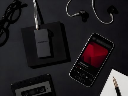 Chytrý telefon, sluchátka, pero, černá audio kazeta na černé ploše, pohled shora