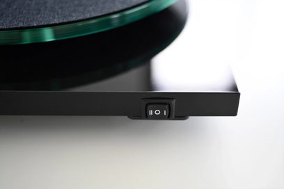 Hi-fi platenspeler Pro-Ject T2 Super Phono met groene glazen draaitafel, zwarte schakelaar gemarkeerd met witte symbolen