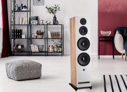 Diffusore a colonna rettangolare con lati in legno chiaro, frontale bianco, 4 altoparlanti circolari neri, base nera