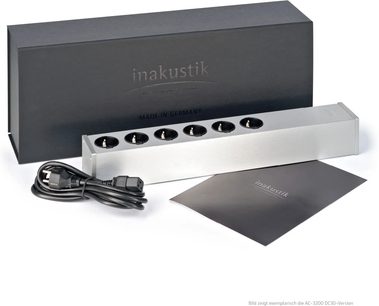 Multizásuvka s ochranou proti přepětí inakustik AC-3200 DC-Blocker SCHUKO v kartáčovaném hliníku stříbrné barvy, šest kulatých černých zásuvek zarovnaných na horní straně, protáhlý obdélníkový tvar, pohled zepředu ze tří čtvrtin