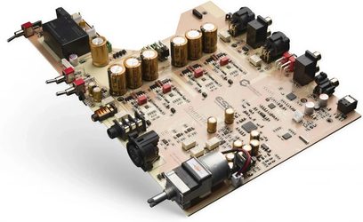 Hovedtelefon-forforstærker i høj kvalitet CMA EIGHTEEN MASTER, printkort set i perspektiv, cylindriske guldfarvede kondensatorer, sorte og røde lydstik, sorte rektangulære komponenter, lyse beige printplader, sorte tekniske inskriptioner, metalliske RCA-stik, sølvfarvet cylindrisk motor med kabler, roterende potentiometer, symmetrisk opstilling af elementerne