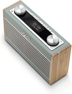 Radio Roberts Rambler Uno i anka blå, rektangulär plastkåpa med ljust trä på sidorna, perforerad frontgrill, svart övre panel med central display och två stora cirkulära metallreglage, perspektivvy i trekvarts vinkel från ovan