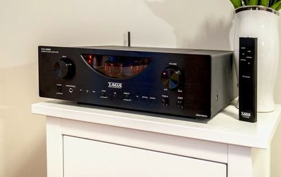 Taga Harmony HTA-1200 sort hi-fi stereoforstærker, set forfra, placeret på en hvid hylde