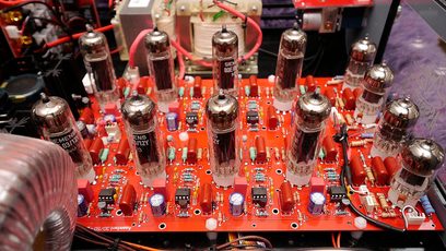 Red printed circuit board of an AudioValve Assistent 50 black hi-fi stereo amplifier, with 12 aligned chrome vacuum tubes