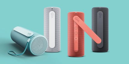 Zylindrische Bluetooth-Lautsprecher von We mit Trageschlaufe in Hellblau, Weiß, Koralle und Dunkelgrau, in Frontalansicht und liegend