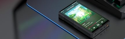 Bærbar lydafspiller i mat sort metal med farveskærm, der viser et albumcover, hovedtelefonstik og knapper på den nederste kant, set i trekvart fugleperspektiv