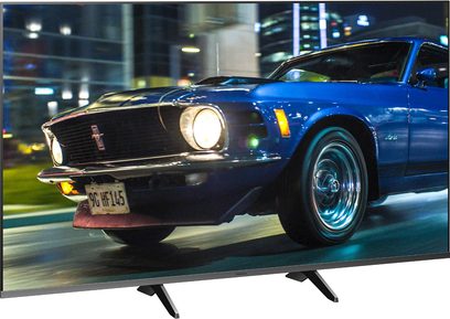Blå 1969 Ford Mustang med nummerplade "9G HF 145", set fra en trekvart forvisning, med en natlig bybaggrund