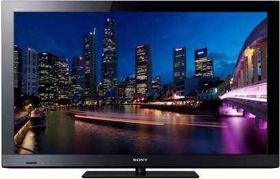 Sony KDL-32CX520 TV-skærm, der viser et natligt vue af oplyste skyskrabere ved vandet med både, der sejler forbi