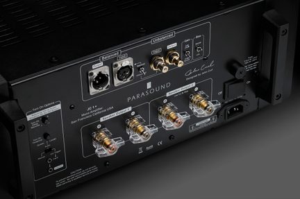 Bagside af en sort lydforstærker med forgyldte XLR- og RCA-stik, kontakter og justeringsdrejeknapper