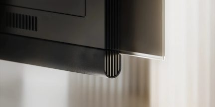 Schwarzer Fernseher, Nahaufnahme der unteren Ecke mit integrierter Soundbar und vertikalem Gitter