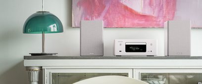 Denon RCD-N10 hvid kompakt audiosystem med CD-afspiller, radiotuner, højttalere og turkis designlampe på hylde