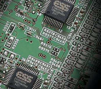 Grønt printplade med sorte og sølvfarvede elektroniske komponenter, tæt og centreret billede