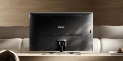 Musta Loewe-televisio takaa nähtynä metallisella keskijalalla nykyaikaisessa olohuoneessa