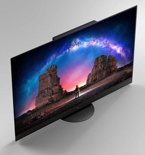 Panasonic TX-65JZ2000E-fladskærm, der viser et billede af et klippelandskab med en person stående under en farverig stjernenat