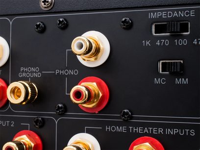 Emotiva XSP-1 stereo forforstærker i sort. Nærbillede af fronten med forgyldte RCA-stik og røde knapper