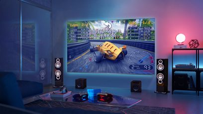 TCL 55QLED760 2022 TV der viser et racerspil, med højttalere og gaming-tilbehør i forgrunden