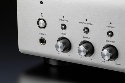 Børstet metallkontrollpanel med dreiebryterne og jackutganger på en sølvfarget Denon PMA-900HNE hi-fi stereoanlegg, sett forfra