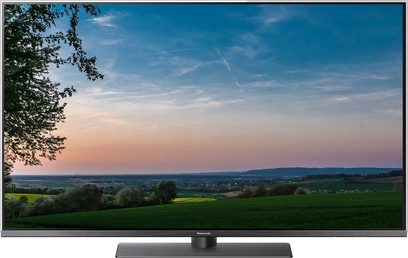 Panasonic TX-49FX780 tv der viser et bakket landskab ved solnedgang, blå og orange farvet himmel