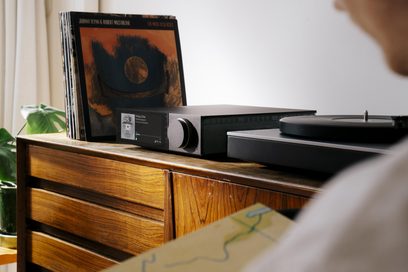 Amplificatore hi-fi integrato stereo Cambridge Audio EVO 150SE nero in alluminio, vista tre quarti anteriore destra, pannello frontale con schermo a colori e doppia manopola circolare