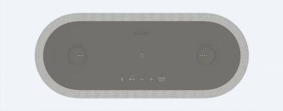 Trådløs tilsluttet højttaler Sony HT-AX7, set ovenfra, oval form, grå overflade, centrerede touch-knapper, tekstureret kant