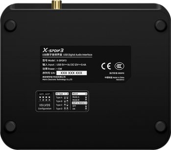 Matrix Audio X‑SPDIF3 digital lydinterface i mat sort aluminium, komplet set fra undersiden, fire gummifødder i hjørnerne og en fremtrædende forgyldt coaxialstik på øverste kant