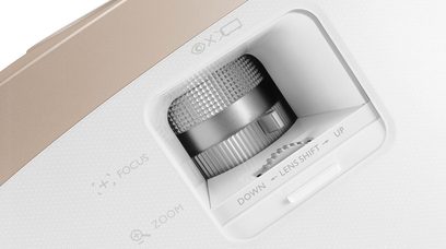 Bílý projektor Benq W2000, detailní pohled zepředu, čočka uprostřed, ventilační mřížky, tlačítka na horní straně