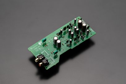 Zelená obdélníková deska plošných spojů s několika černými a stříbrnými elektronickými součástkami připájenými na povrchu