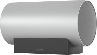 Sub Medium Wireless sølv subwoofer, sett fra siden, sylindrisk form, sirkulært gitter, svart rektangulær støtte