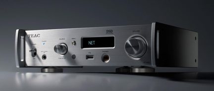Šlifuoto metalo sidabrinis audio komponentas, iš trijų ketvirčių priekio, ekranas su užrašu „NET“, didelis garsiojo reguliavimo mygtukas, USB ir ausinių lizdas