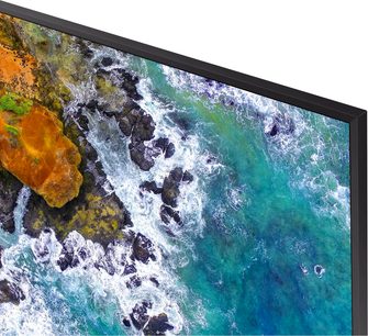 Samsung UE50NU7475-TV som viser et luftfoto av en steinete kyst og et turkisblått hav med skummende bølger
