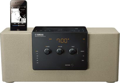 Yamaha TSX-140 grå, dockingstation med LCD-skærm der viser "7:00 AM", kontrolknapper, dock til smartphone, på beige overflade