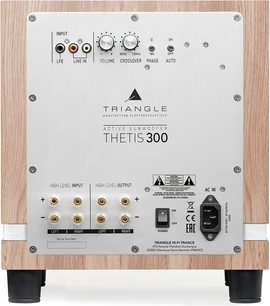 Triangle Thetis 300 subwoofer i lys eik-finish, bakside med trekabinett og stor sølvfarget aluminiumsplate utstyrt med RCA-innganger, høynivåterminaler, volum- og delefrekvensknapper, bryter og strømkontakt