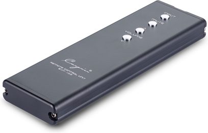 Rectangular remote control in anthracite gray metal Cayin Jazz 100 silver, three-quarter view, with four chrome circular buttons aligned on the top