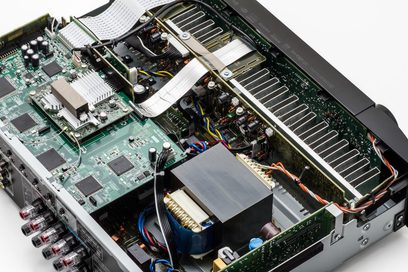 Indvendigt syn af en åben sort Marantz NR1509 lydforstærker, der viser de elektroniske komponenter på det grønne printplade