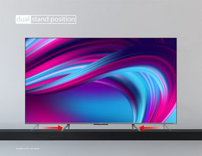 TCL 50QLED760 2022 TV set forfra, tændt skærm der viser flydende, farvede abstrakte former, to synlige støtteben
