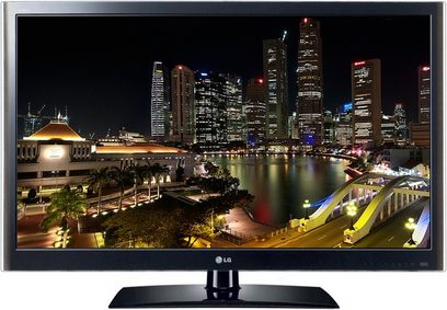 LG 32LV5500 TV-skærm, der viser et natligt vue af oplyste skyskrabere og deres spejlinger i en vandoverflade