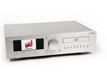 Alüminyum fırçalı gümüş renginde tümleşik hi-fi sistemi Block CVR-100+ MKIII, üç çeyrek ön görünüm, büyük renkli ekran, geniş merkez düğme, CD okuyucu yuvası ve ön panelde düğme ve bağlantı noktaları sırasıyla donatılmış