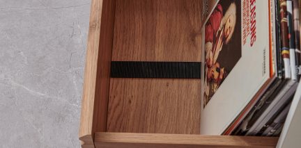 Fugleperspektiv av en skuff i tre som inneholder vinylplater justert til høyre og et horisontalt svart bånd i midten