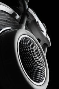 AKG K701 sølvfarvet hovedtelefon, nærbillede af højre profil, hexagonal metalrist på oval ørepude
