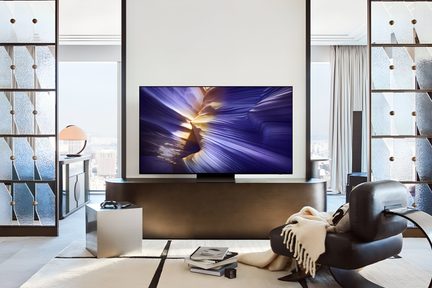 Sort fladskærms-tv i glas, med smal ramme, set forfra, på mørkt møbel i en moderne stue