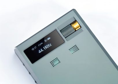 Bærbar lydkonverter Cayin RU9 i anodiseret grøn salvie-aluminium, set fra en trekvart vinkel ovenfra, med sort OLED-skærm, mønstret volumenhjul i metalgrå med gylden spids og to firkantede, gennemlyste gitter med cyan baggrundsbelysning