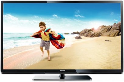 Philips 32PFL3507H-fladskærm, der viser et barn med en farverig oppustelig svømmering, der løber på en strand med fint sand